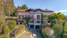 two-story house, pink exterior, brown roof, balconies, garage, raised ground floor