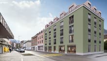 modern 5-storey building, windows, balconies, shops at the bottom floor, entrance with stairs