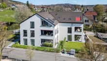 2 story house, white exterior, brown roof, multiple windows, balconies, solar panels, garden, driveway