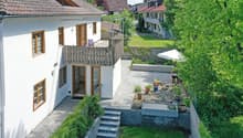 white house, brown roof, balcony, paved patio, garden, steps