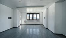 empty room, white walls, gray floor, large window, radiator