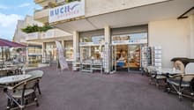 Buch paradies retail store with outdoor seating area, displays of books and other merchandise in the storefront windows