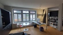 office room with desk, chairs, computer, books, storage boxes, shelves, radiator, window