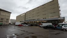 multi-storey building, parking lot, grey exterior, multiple windows, parked cars