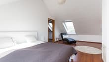 bedroom with a bed, pillows, duvet, and white rug