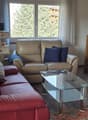 large couch, coffee table, TV, small table with speaker, window, stairs