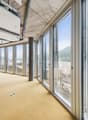 Wide windows with city view, carpeted floor, central column