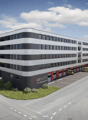 multi-story building, ambulance bay, large parking lot, ambulance