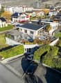 Modern architectural design, rooftop terrace, several parking spaces, green surroundings