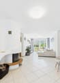 white walls, tiled floor, fireplace, couch, armchair, plant, table, lamp