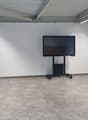 room with tiled floor, two chairs, mounted monitor, wooden door