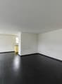 / an empty living room with black floors and a large sliding door
