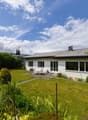 / a large white house with a garden and lawn in the countryside