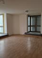 empty room, wooden floor, large windows, white walls, ceiling lights