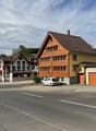 Houses on the street, brown roof, yellow walls, garage, cars parked in front