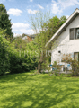 modern single family house, white walls, red roof, large garden, patio, raised ground floor