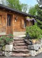 Villa / a wooden house with a stone wall and plants on the wall