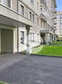 Entrée de l'immeuble avec parking visiteurs dans rue calme