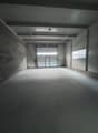 Empty room, industrial style, brick wall, white ceiling, overhead lighting, white door, fire extinguisher, window, wide open entrance