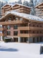 3 story wooden chalet, snowy roof, multiple balconies, covered driveway