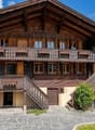 wooden chalet, 3 stories, wooden balcony, stone wall, wooden fence, garden