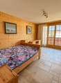 wooden walls, bed, desk, TV, glass doors, tiled floor