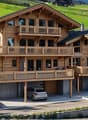 Detached house with wooden exterior, three-levels, three balconies, garage, multiple parking places