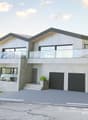 2 story house, gray concrete, 2 garages, large balcony, steps, landscaped area