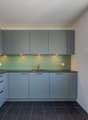 Modern kitchen, gray cabinets, black countertops, stainless steel faucet, large window