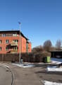 3 story brick building, balconies, street light, cars parked in garage