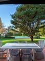 outdoor dining table with chairs, swimming pool, lawn, garden, house, trees