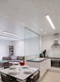 Open plan living room and kitchen, dining table, couch, bookshelves, kitchen appliances