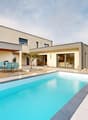 Modern house, swimming pool, patio, patio table and chairs, white walls, glass doors