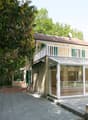 2-story house with a terrace and a glass-enclosed porch, raised ground floor with terrace