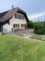 2 story house, brown roof, beige walls, large garden, patio, shed