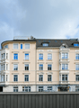 5 story building, beige facade, multiple windows, modern architecture