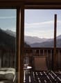 Wooden railing, outdoor furniture, open to terrace with view of mountains