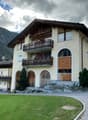 two story building, balconies, large grassy field, trees, mountains