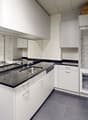 modern kitchen, white cabinets, granite countertops, stainless steel sink, dishwasher, private washing machine, open refrigerator, ceiling fan