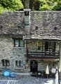 Stone house, wooden door, balcony, garden, green surroundings