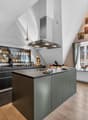 modern kitchen with island, wine rack, large windows, wooden floor