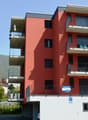 apartment building, red brick, multiple balconies, private parking