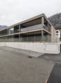 multistory house, modern architecture, glass windows, concrete fence, garage, parking lot