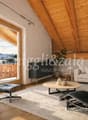 wooden ceiling, large windows, balcony, couch, coffee table, armchairs, rug