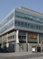 modern office building with large windows, COOP banner on the front, colorful murals on the walls