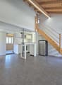open floor plan, wooden ceiling, white walls, gray floor, kitchen, staircase, refrigerator, fireplace