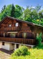 Traditional wooden house, 2 story, balcony, surrounded by greenery