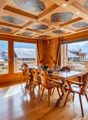 Dining table, wooden chairs, large windows, balcony with table and chair, wooden flooring, decorative ceiling
