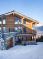 wooden, two stories, balcony, glass windows, elevated entrance, mountains in background