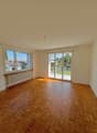 empty room, wooden parquet floor, large windows, sliding glass doors, balcony, white walls, white radiator